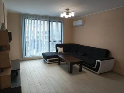 a living room with a black couch and a table at Мариана in Plovdiv