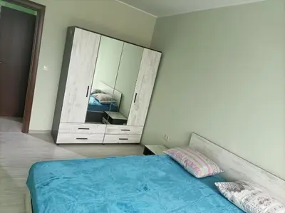 a bedroom with a bed and a large mirror at Мариана in Plovdiv