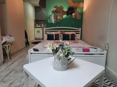 a bedroom with a bed and a table with flowers at Studio for guests Catherine in Sofia