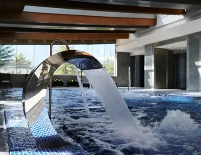 a water fountain in the middle of a swimming pool at Cozy apartment in luxury SPA resort St Ivan Rilski Bansko -free wellness & parking- in Bansko