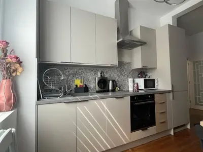 a kitchen with white cabinets and a black oven at Diva Kapana 2BDR Apartment with parking in Plovdiv