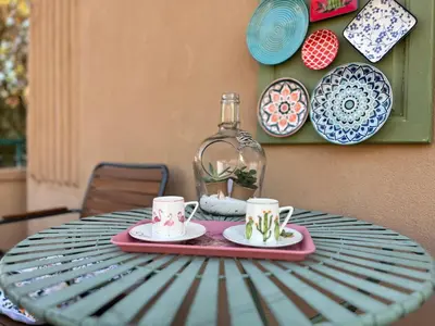 a table with two cups and a bottle on it at Diva Kapana 2BDR Apartment with parking in Plovdiv