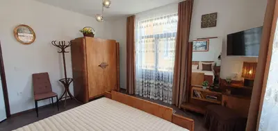 a bedroom with a bed and a tv and a window at АПАРТАМЕНТ ЮЛИЯ ДЕЛУКС II in Velingrad