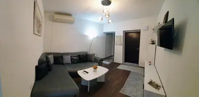 a living room with a couch and a table at АПАРТАМЕНТ ЮЛИЯ ДЕЛУКС II in Velingrad