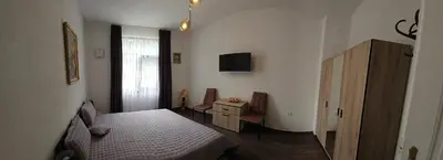 a bedroom with a bed and a tv and a window at АПАРТАМЕНТ ЮЛИЯ ДЕЛУКС II in Velingrad