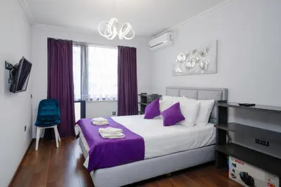 a bedroom with a large bed with purple accents at Feel at Home - Central 2BD Flat with Parking by Flat Mаnager in Sofia