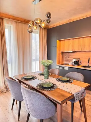 a dining room with a wooden table and chairs at Lux Apart Karlovo 1 in Karlovo