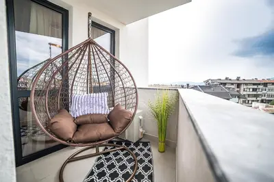 a rattan swing chair on a balcony at Lux Apart Karlovo 1 in Karlovo