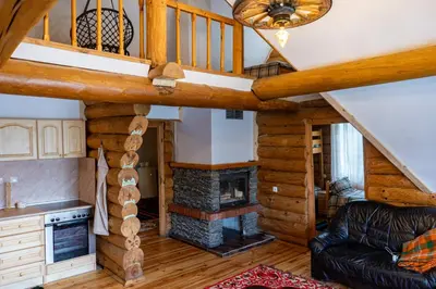a living room with a staircase and a fireplace at Lambievi Kolibi in Gorno Kraishte