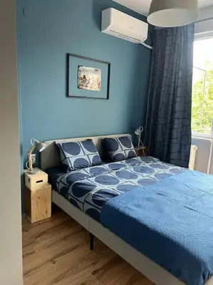 a blue bedroom with a bed and a window at Brand NEW! 2BDR Lux Apartment RAYKO in Sofia