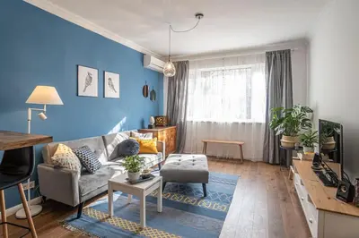 a living room with a couch and a blue wall at Cozy Apartment Overlooking The Park in Sofia