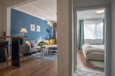 a room with a bed and a living room at Cozy Apartment Overlooking The Park in Sofia