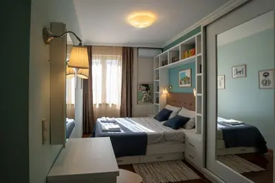 a small bedroom with a bed and a mirror at Home in Sofia's Beating Heart in Sofia