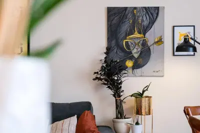 a living room with a painting of a cat wearing glasses at Home in Sofia's Beating Heart in Sofia