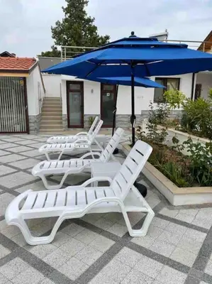 three lounge chairs and an umbrella on a patio at Boris House 5 bed Villa & Private Pool in Strumyani