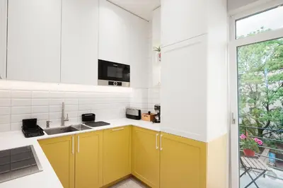 a kitchen with yellow cabinets and a window at Brand New 2 bdr Luxury Apartment in Top Centre in Sofia