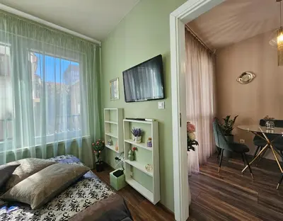 a bedroom with a bed and a table and a window at Bright Inn - Holiday & Business Apartment in Sofia