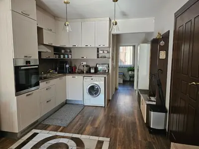a kitchen with white cabinets and a washer and dryer at Bright Inn - Holiday & Business Apartment in Sofia