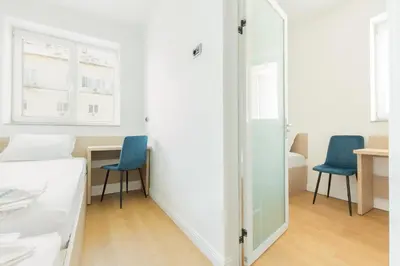 a bedroom with two blue chairs and a table at Millennia Hotel in Sofia