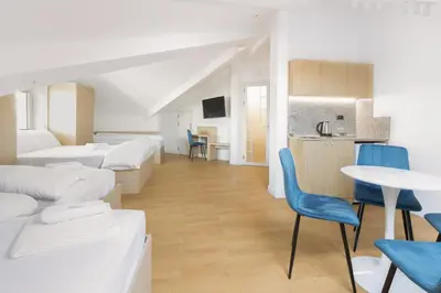 a room with white beds and a table and chairs at Millennia Hotel in Sofia