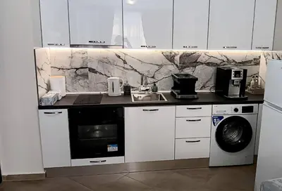 a white kitchen with a sink and a washing machine at Doble next to Bulgaria mall, FREE underground parking in Sofia