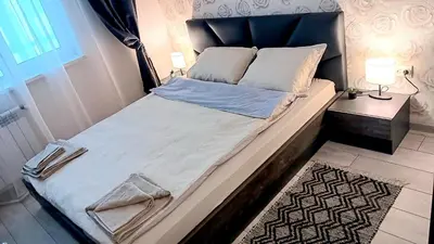 a large bed in a bedroom next to a door at Doble next to Bulgaria mall, FREE underground parking in Sofia