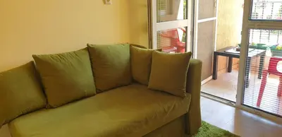 a brown couch in a living room with a window at Private studio in the city center, close to subway, Medical University in Sofia