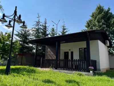 a small house with a black roof at Bungalows of Yug in Kyustendil