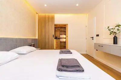 a bedroom with a white bed and a closet at Sunset 2BR Apartment Central Street PARKING Included in Plovdiv