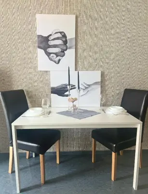 a table with two chairs and a white table with two pictures at Flower house 6 in Sofia