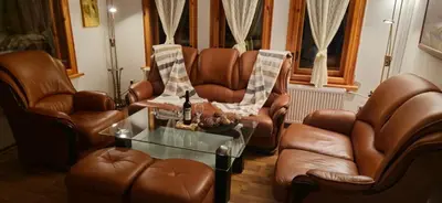 a living room with leather chairs and a table at Къща за гости Бели Вит in Ribarica