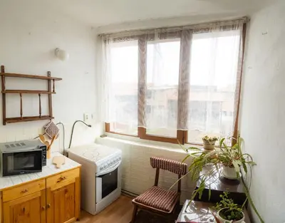 a small kitchen with a stove and a window at Стаи за гости Божана in Razlog