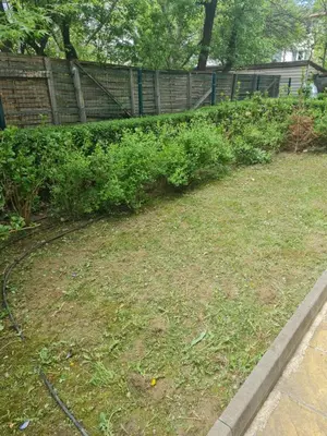 a garden with a fence and some bushes at Cozy studio with balcony in Sofia