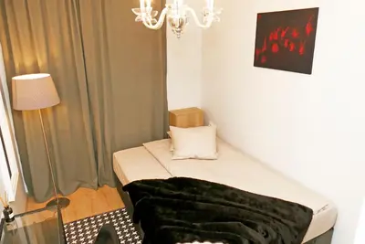 a small bed in a room with a chandelier at Dom Knipituga in Sofia
