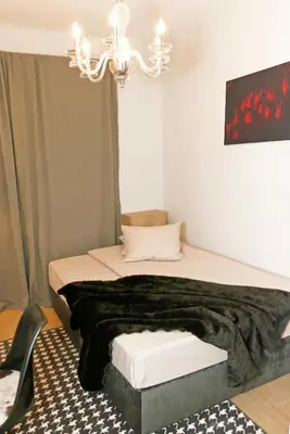 a bedroom with a bed and a chandelier at Dom Knipituga in Sofia