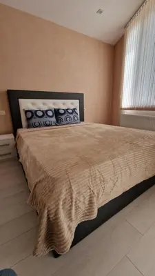 a bedroom with a large bed and a window at Апартаменти Недялкови I in Sandanski
