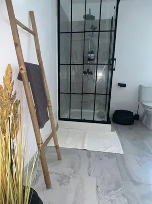 a bathroom with a glass shower and a toilet at Rodopi Mountain Village House in Narechen