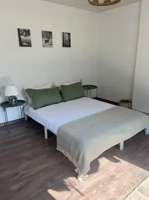a large bed in a room with two tables at Rodopi Mountain Village House in Narechen