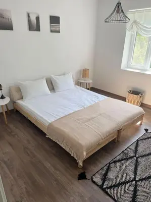 a bedroom with a large bed with white sheets at Rodopi Mountain Village House in Narechen