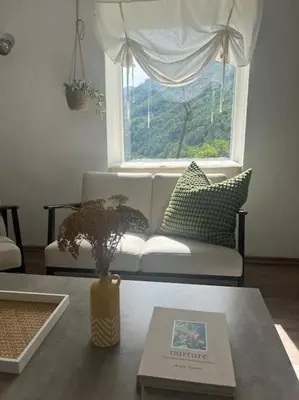a living room with a couch and a window at Rodopi Mountain Village House in Narechen
