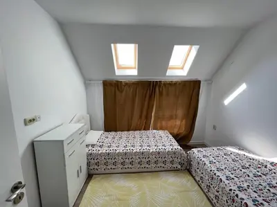 a bedroom with two beds and a dresser and two windows at Sandanski escape in Sandanski