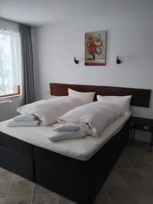 a bed with white sheets and pillows on it at D Villa in Mineralni Bani