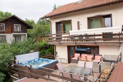 a balcony with a hot tub and chairs and a house at Kalina i Sokol spa in Pchelin
