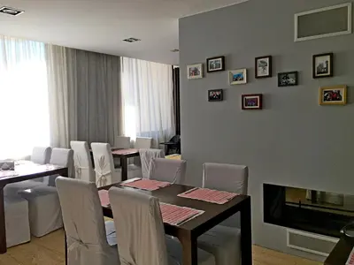 a dining room with tables and chairs and a fireplace at GT Aspen House Apartments in Bansko