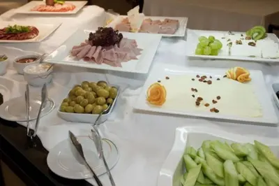 a table topped with different types of food on plates at GT Aspen House Apartments in Bansko