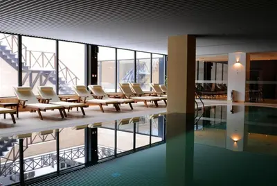 a building with a swimming pool and chairs and a building at GT Aspen House Apartments in Bansko