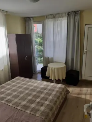 a bedroom with two beds and a table and a window at Easy rooms in Sapareva Banya