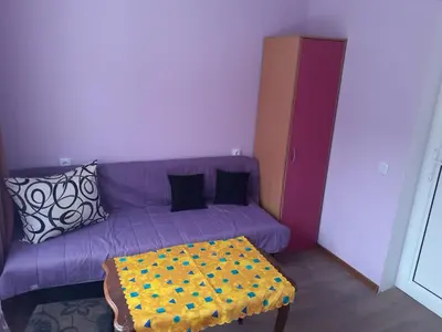 a purple couch with pillows and a table in a room at Easy rooms in Sapareva Banya