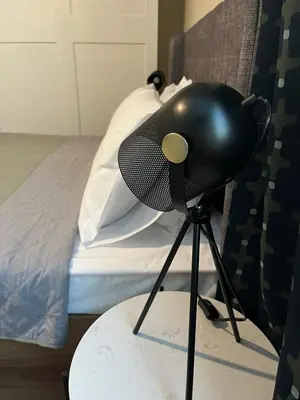a black chair sitting on a table next to a bed at EL apartment in Sofia