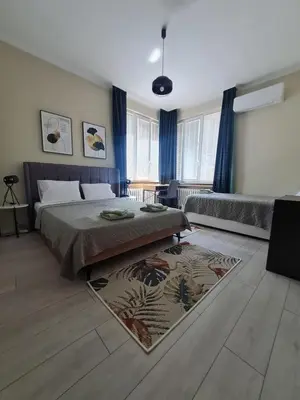 a bedroom with two beds and a rug at EL apartment in Sofia